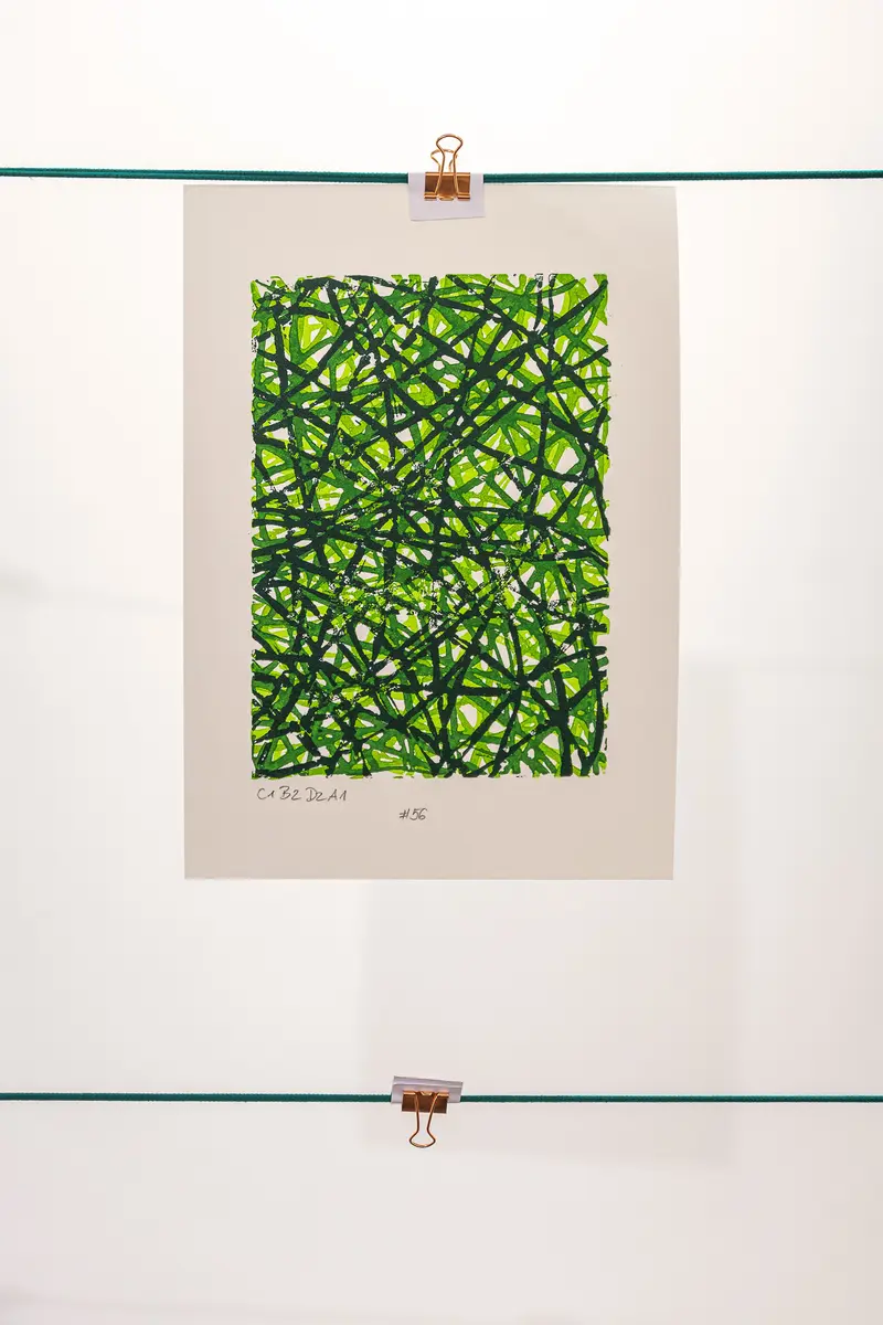Green Geometric Abstract Print Hung with Binder Clips on White Wall