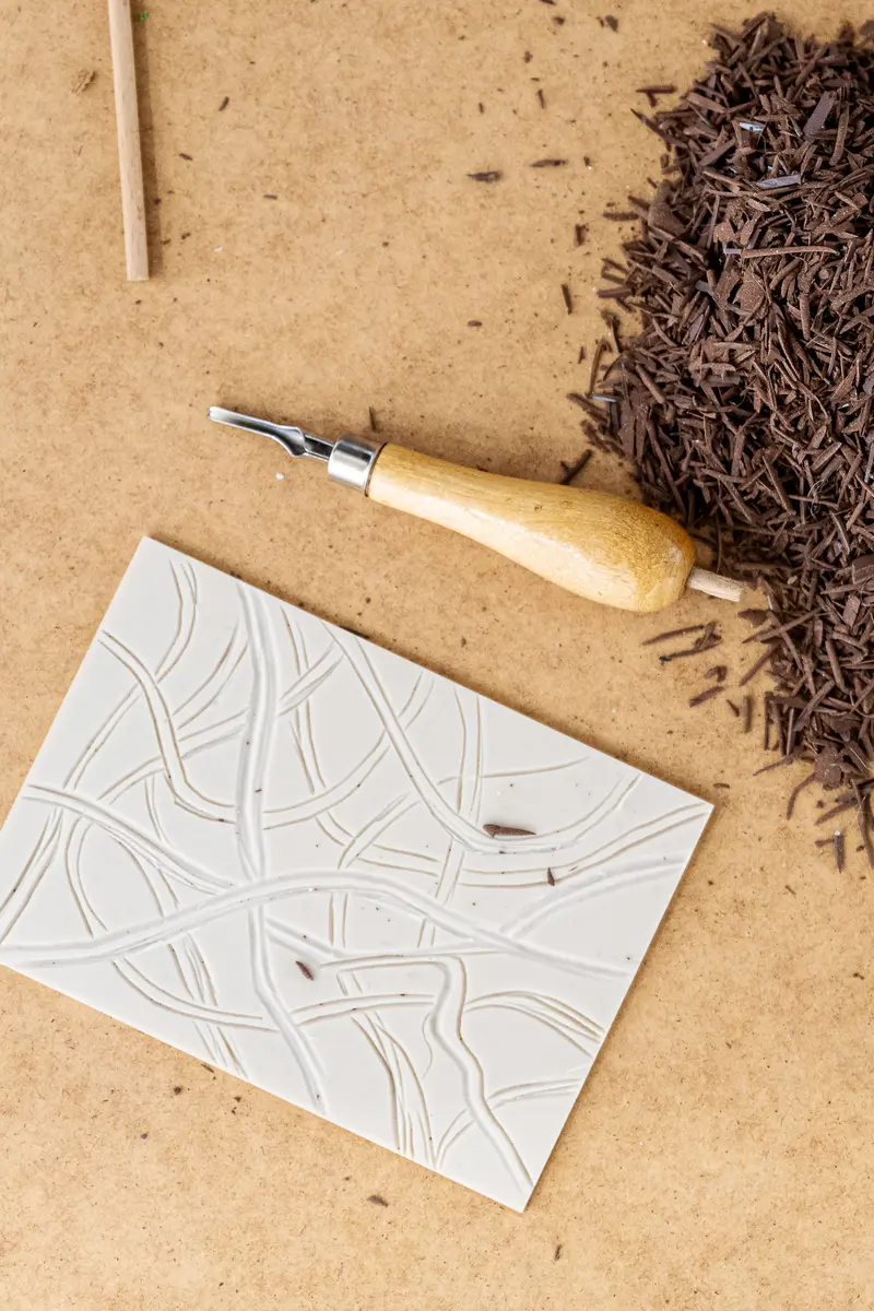 Printmaking Tools: Carving Blade, Woodcut Paper, and Wood Shavings