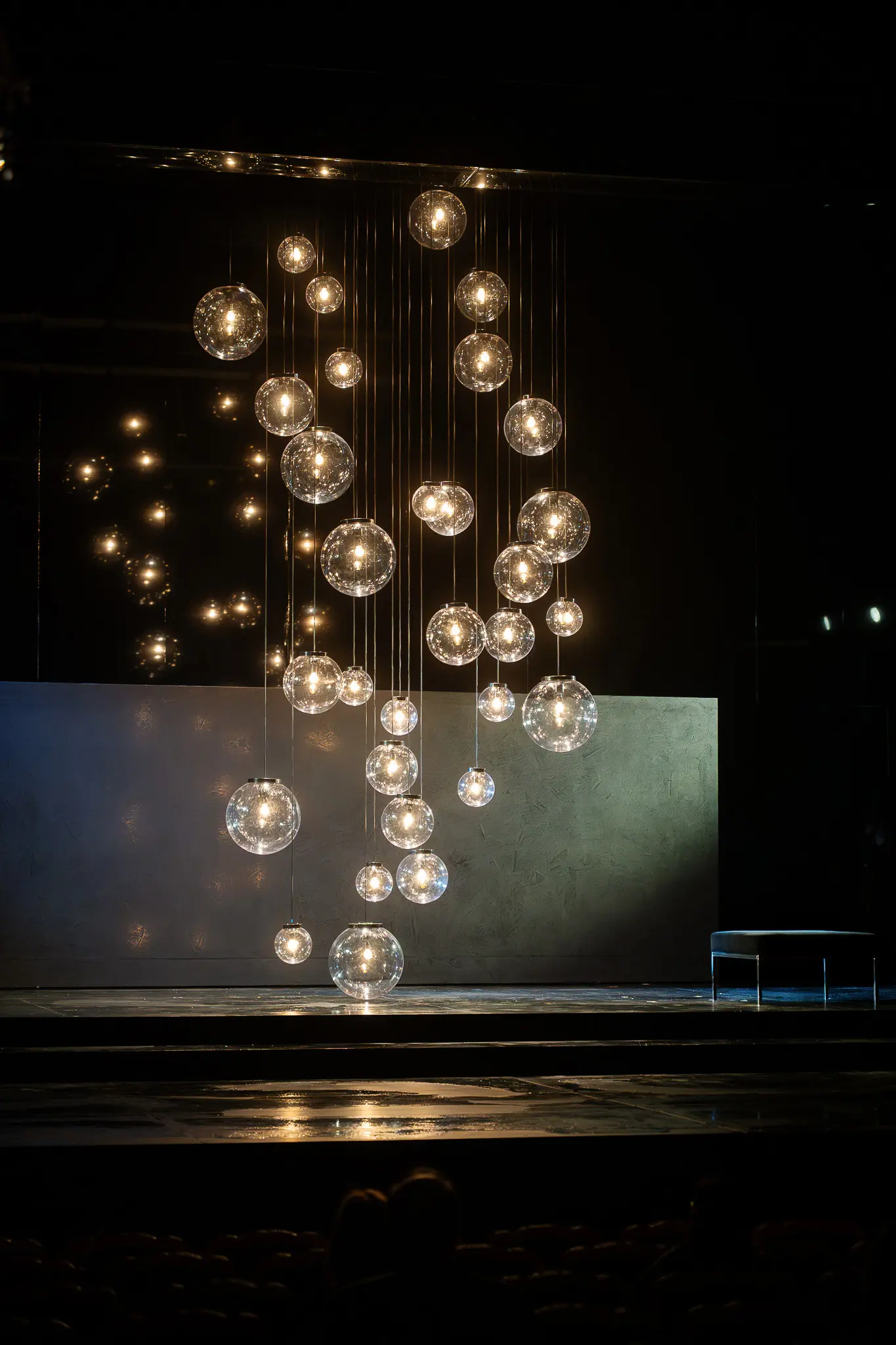 Suspended Glass Sphere Light Installation in Dramatic Theater Setting