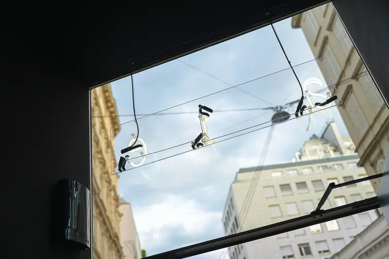 Surveillance Cameras Mounted on Urban Overhead Wire Against City Architecture
