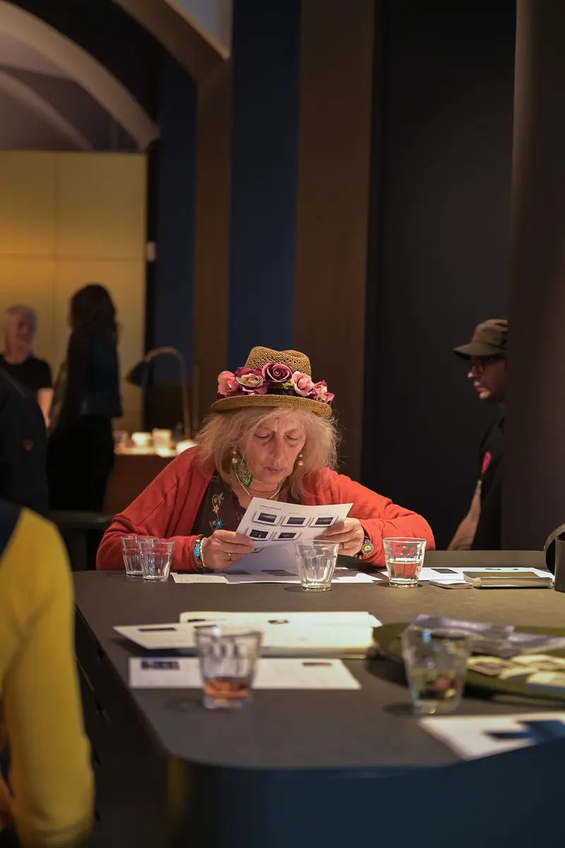 Attendee in Floral Hat Reading at "Poem of Darkness" Gallery Vernissage