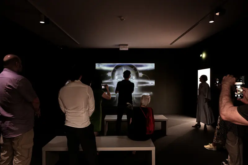 Museum Visitors Viewing Dark Artistic Projection Screen Installation