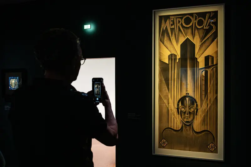 Vintage Metropolis Film Poster Display with Museum Visitor Photography