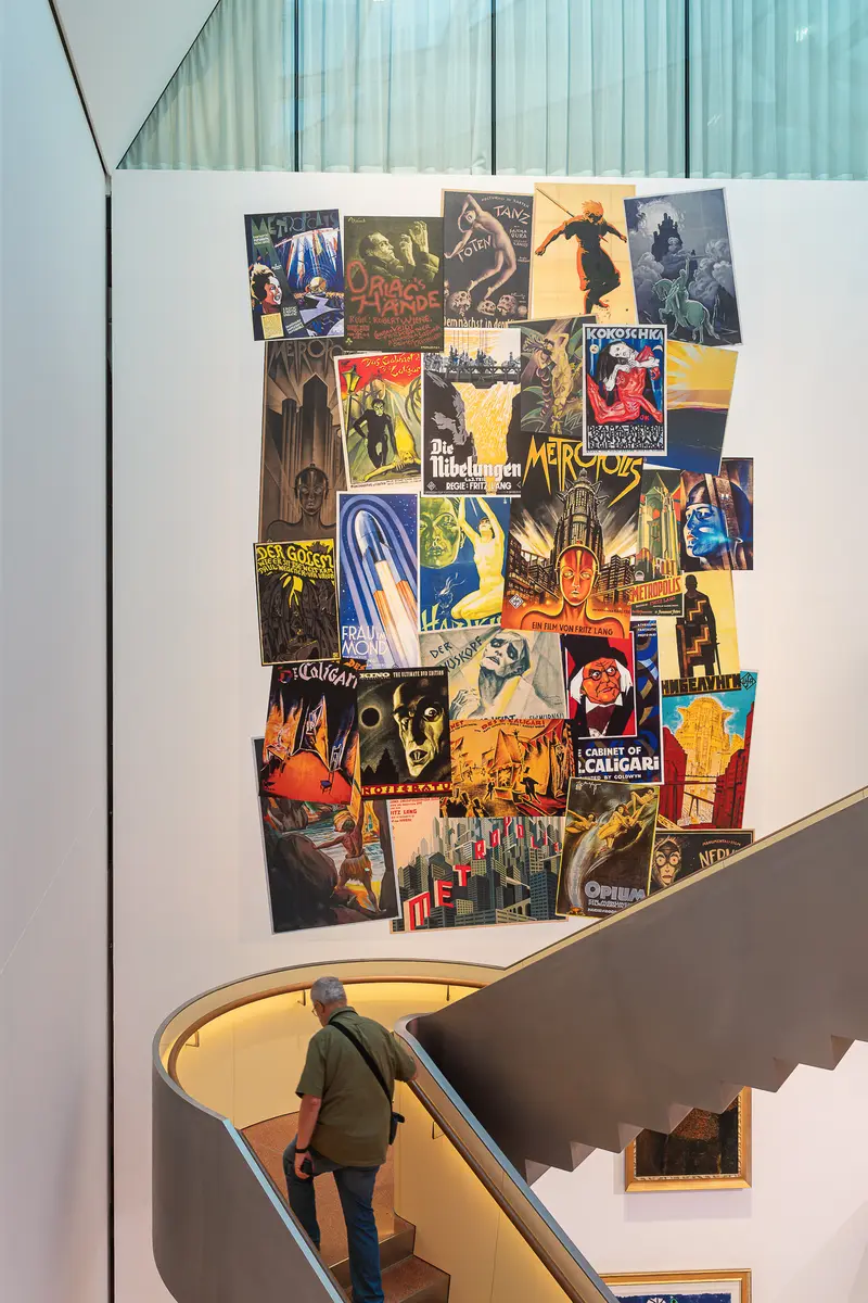 Vintage Poster Wall Display in Modern Museum Stairwell