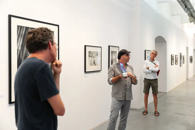 Exhibition Visitors Studying Photographs at Ostlicht Gallery Photography Exhibition