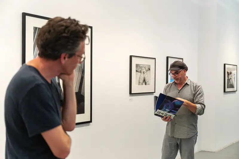 Exhibition Attendees Studying Black and White Photographs at Araki Show