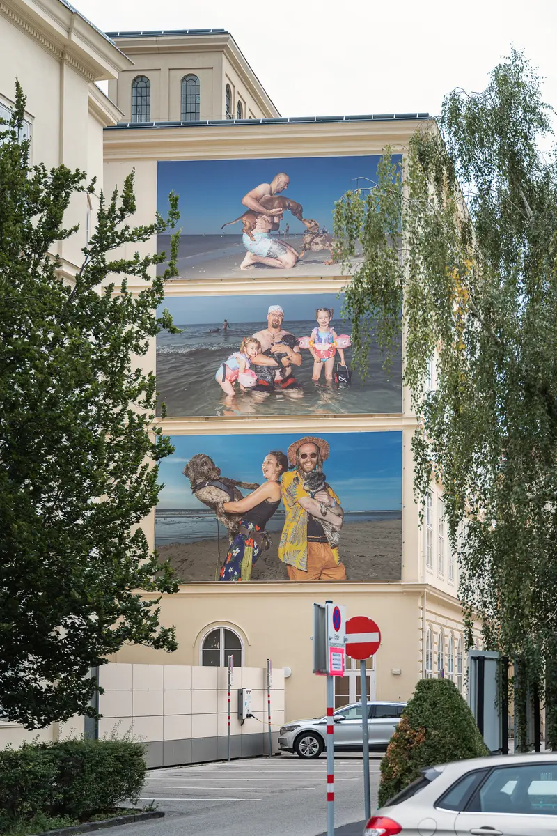 Photographic Mural Depicting Family Scenes on Urban Building Exterior