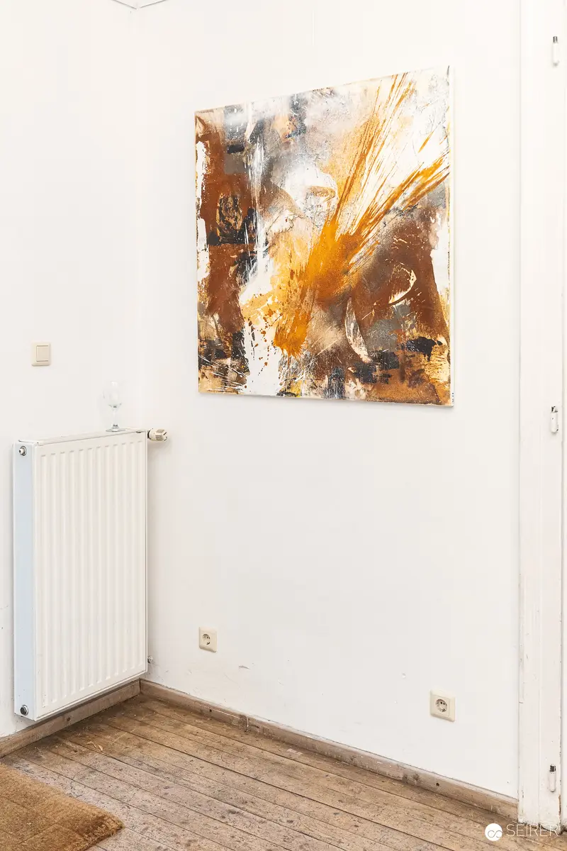 Abstract Orange and Brown Painting Mounted on White Wall Near Radiator