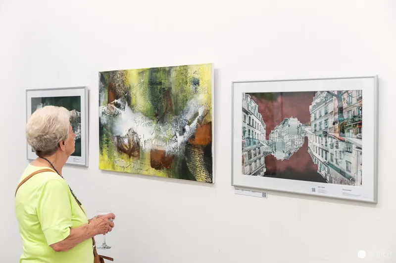 Senior Visitor Examining Abstract and Urban Artworks at Gallery Exhibition