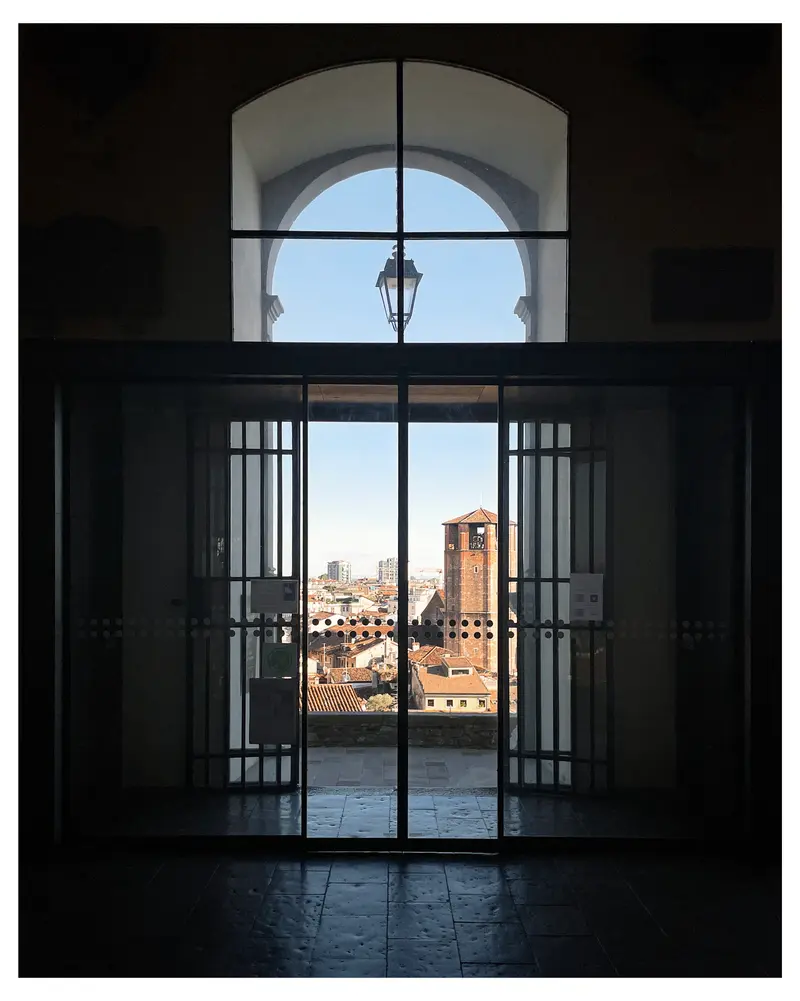 Framed Urban Landscape: View of Historic City through Arched Window