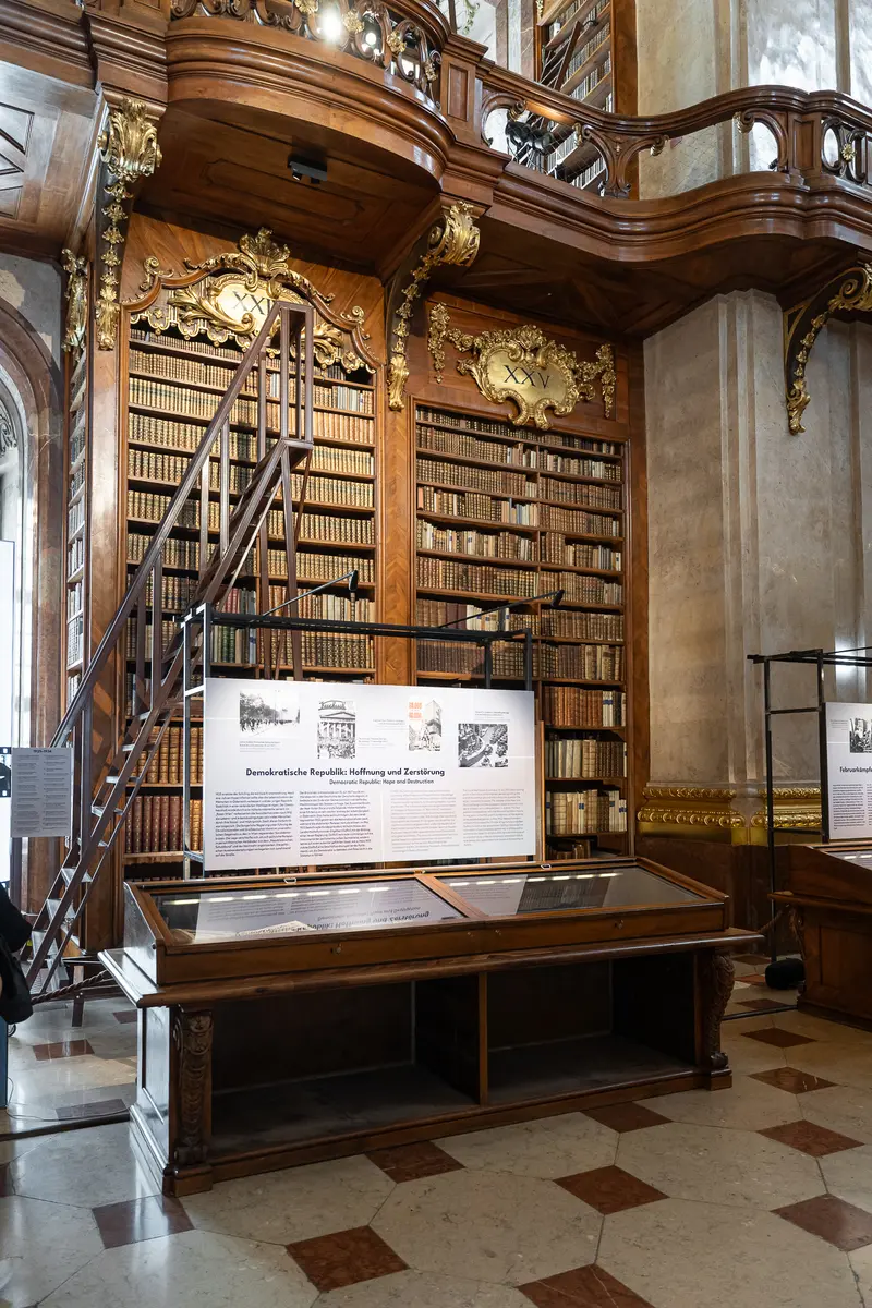 Ornate Austrian National Library Hall with Wooden Bookshelves and Spiral Staircase
