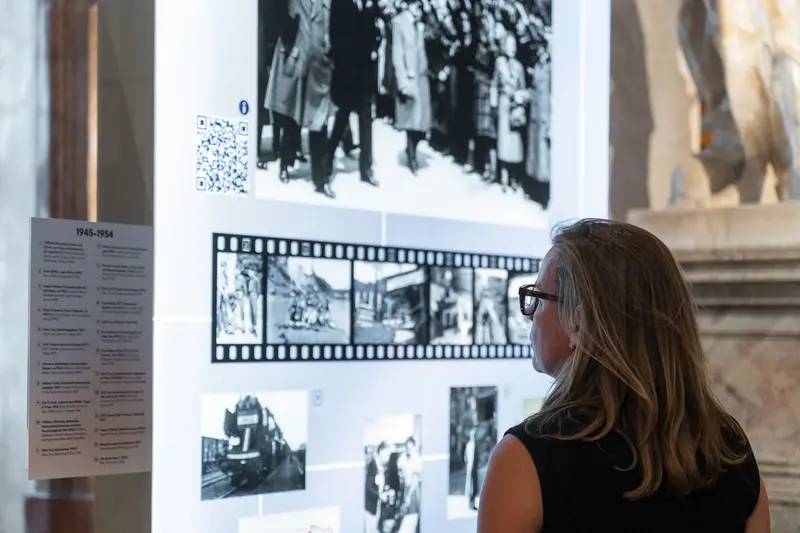 Visitor Examining Historical Black and White Photography Exhibition