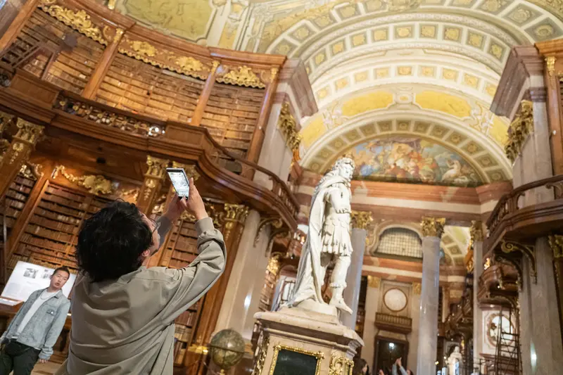 Visitors Explore Ornate Austrian National Library During Exhibition Tour