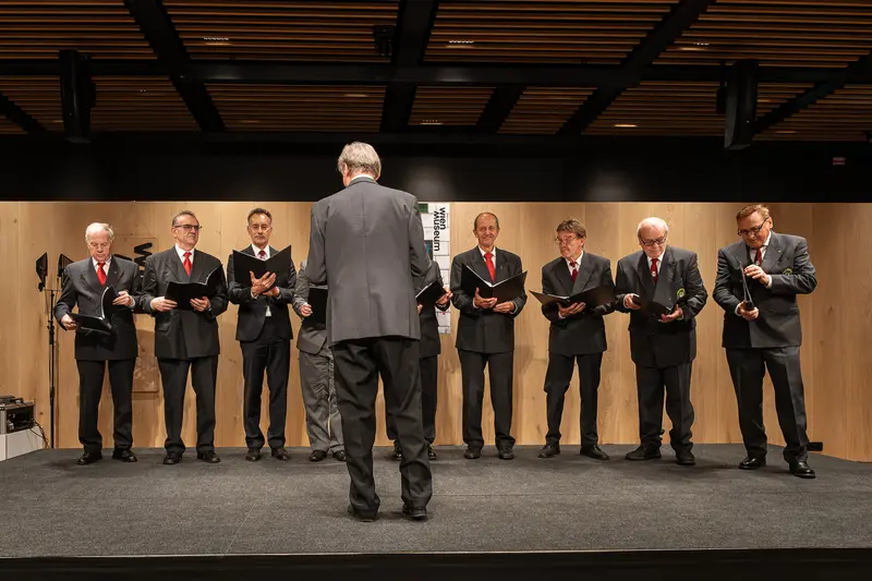 Men in Suits Performing Synchronized Reading at Formal Event