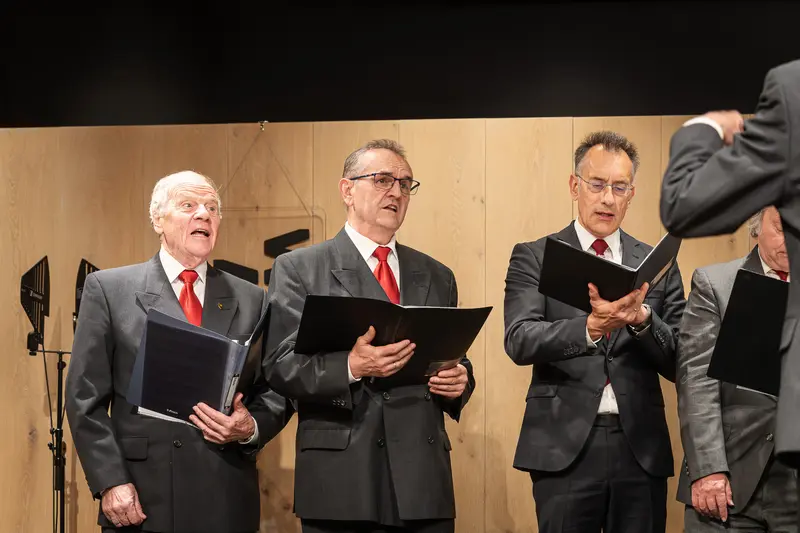 Senior Male Choir Performers in Matching Suits and Red Ties