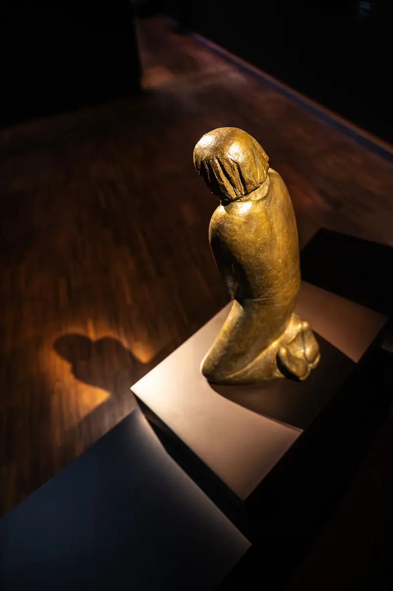 Golden Statuette in Dramatic Lighting at Gothic Modern Exhibition