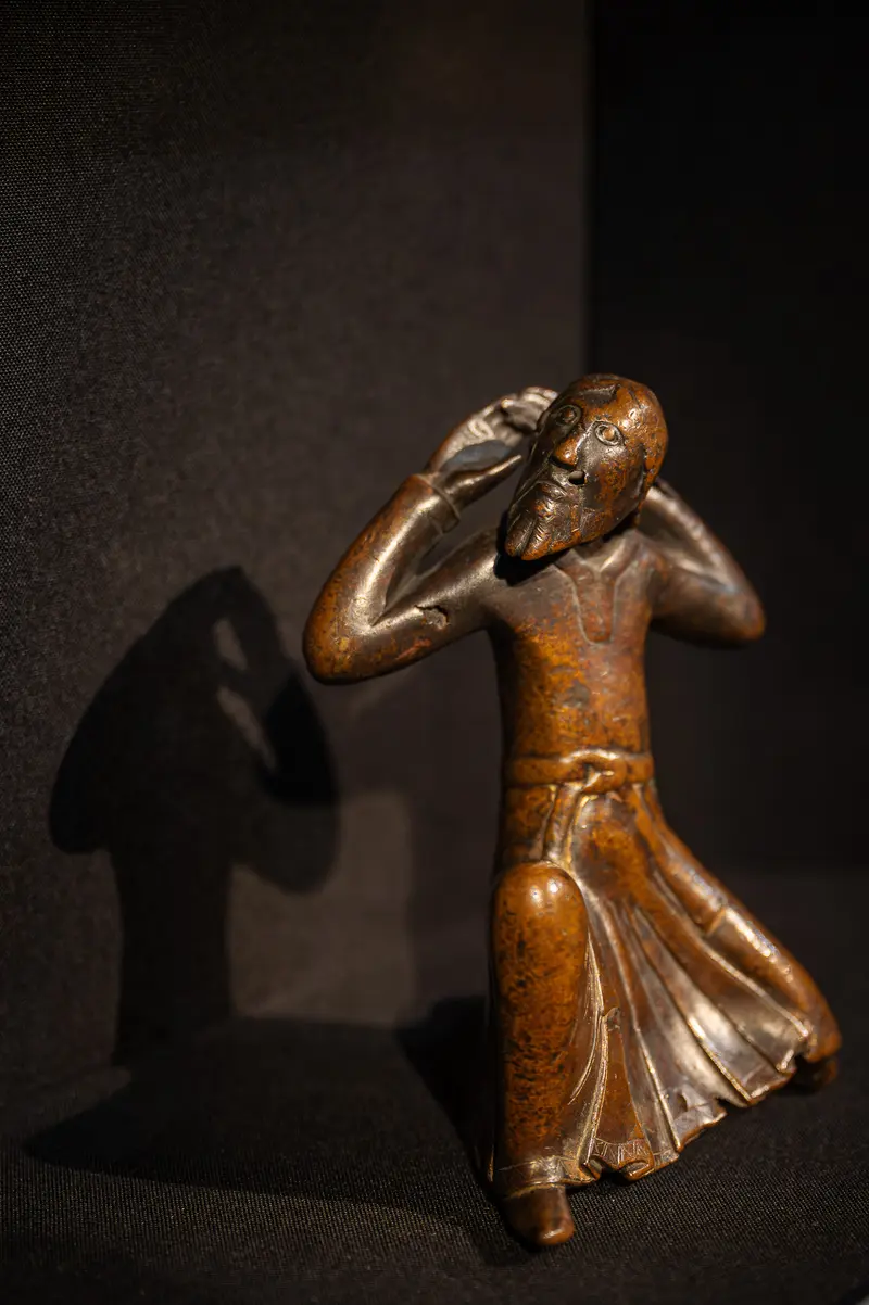 Bronze Sculpture of a Contemplative Figure Casting Dramatic Shadow