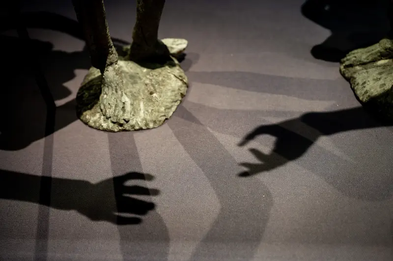 Shadows and Stone: Surreal Geological Form with Hand Silhouettes