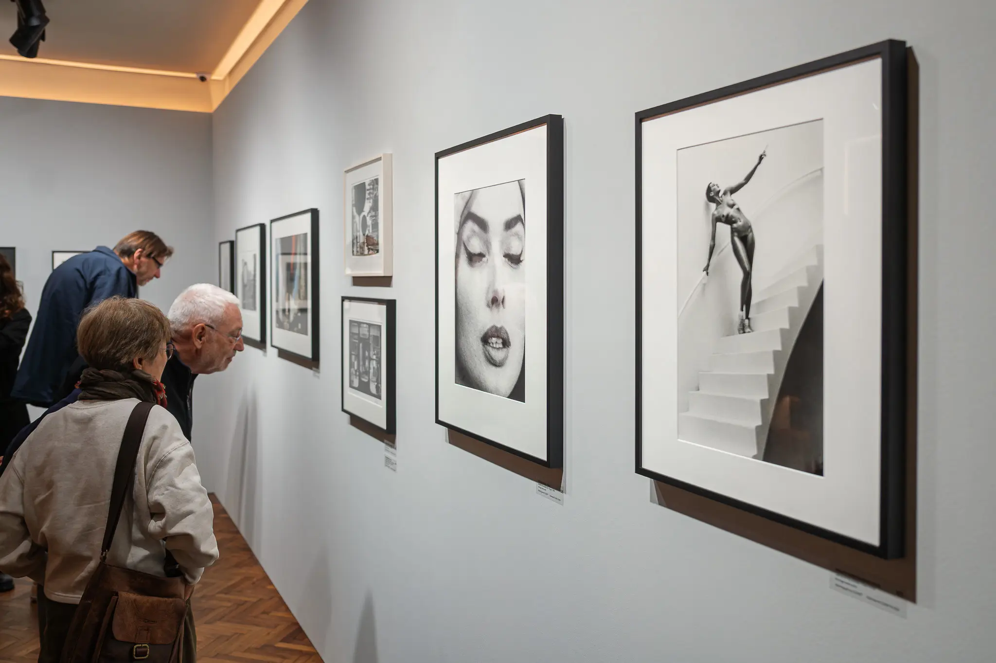 Gallery Visitors Examining Black and White Fine Art Photography Exhibit