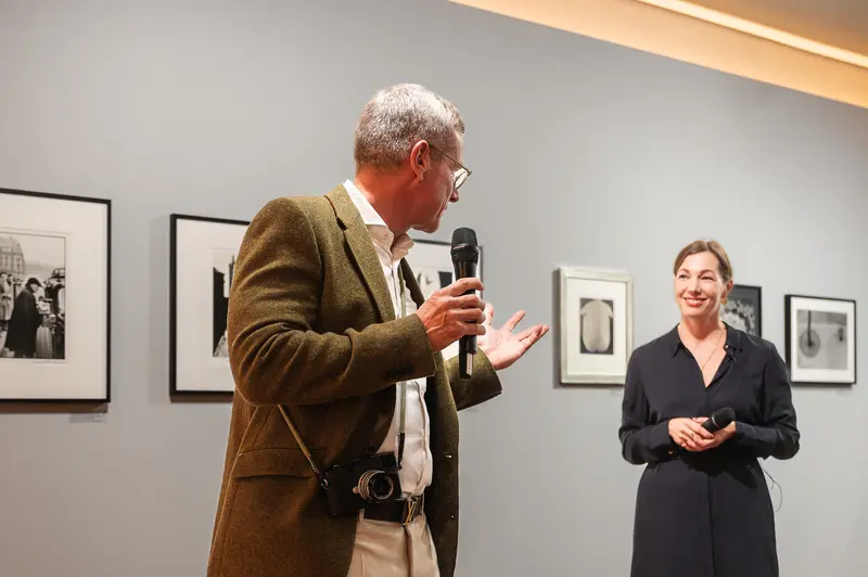Museum Curator Discusses Photographic Exhibition During Opening Event