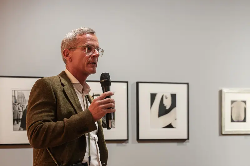 Art Gallery Speaker in Brown Jacket Presenting During Exhibition Opening