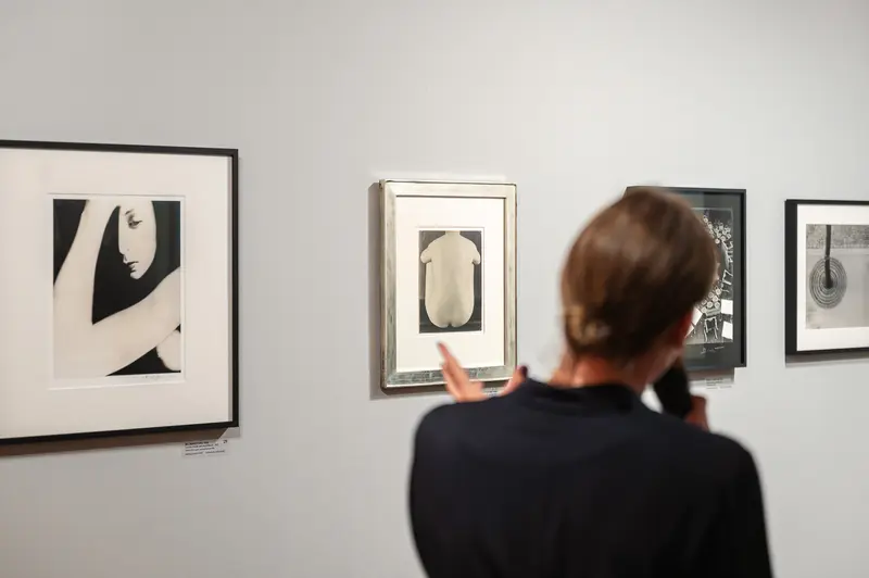 Museum Visitor Examining Black and White Photographic Artworks
