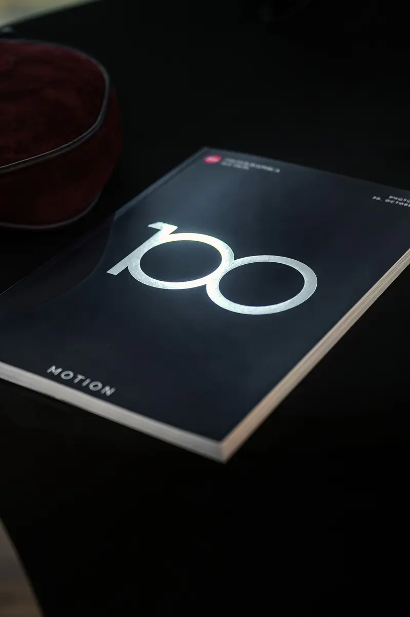 Minimalist Design Book with "100" Logo on Dark Background