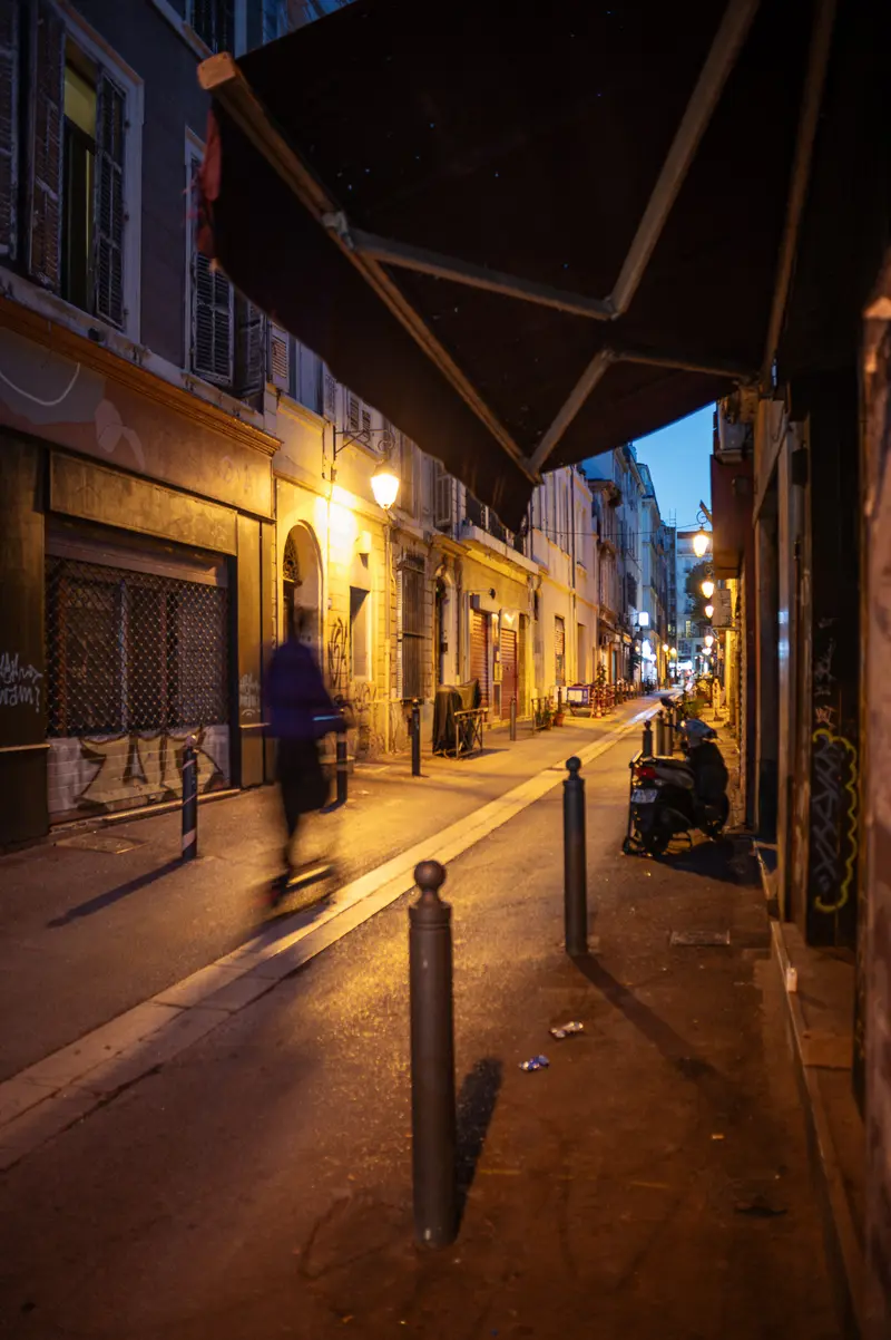 Nighttime Street Scene in Marseille with Blurred Pedestrian Movement