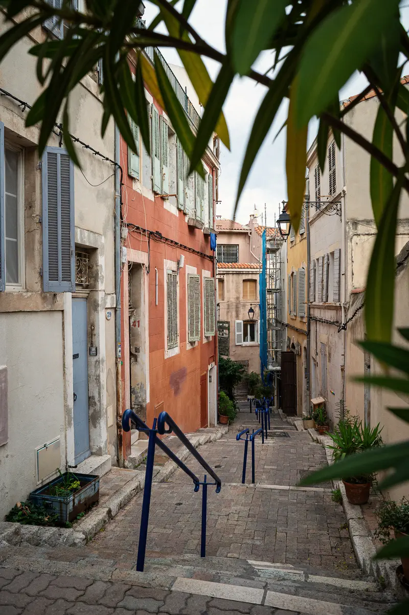 Narrow Cobblestone Alley in Marseille with Colorful Mediterranean Buildings
