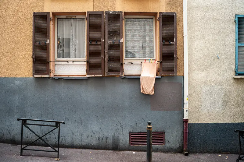 Weathered Marseille Facade with Open Shutters and Hanging Cloth