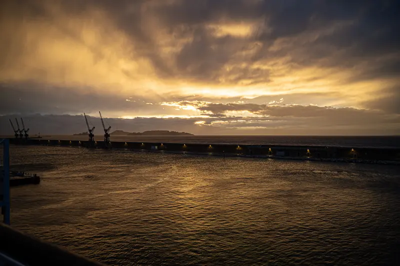 Golden Sunset Over Marseille Harbor with Industrial Cranes