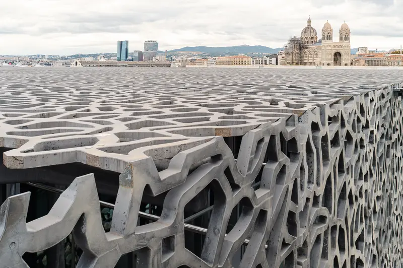 Marseille's MuCEM: Intricate Concrete Facade with Cathedral and Cityscape Backdrop