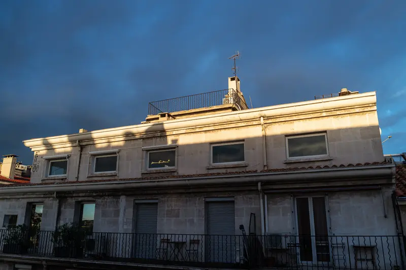 Sunlit Marseille Building at Dusk with Dramatic Blue Sky Background