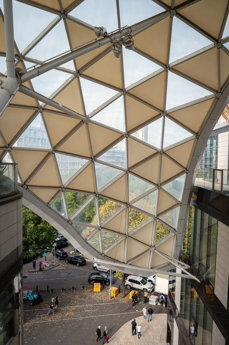 Geometric Glass Dome Structure with Triangular Panels Over Urban Streetscape
