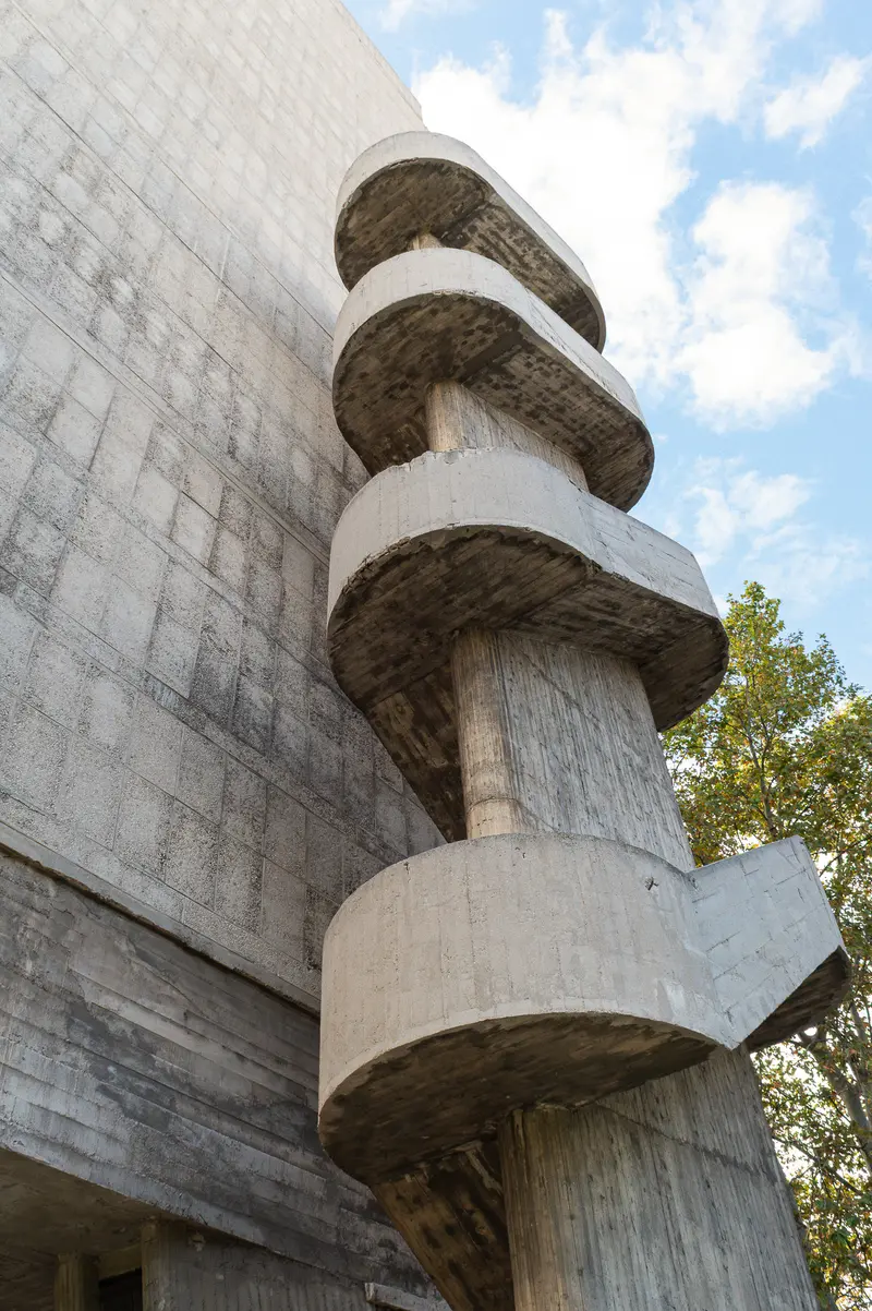 Concrete Spiral Staircase Integrated with Brutalist Architectural Wall Design