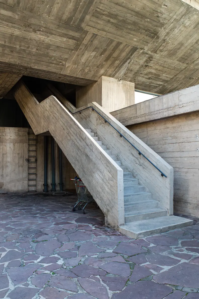 Concrete Staircase in Brutalist Architecture with Irregular Stone Floor