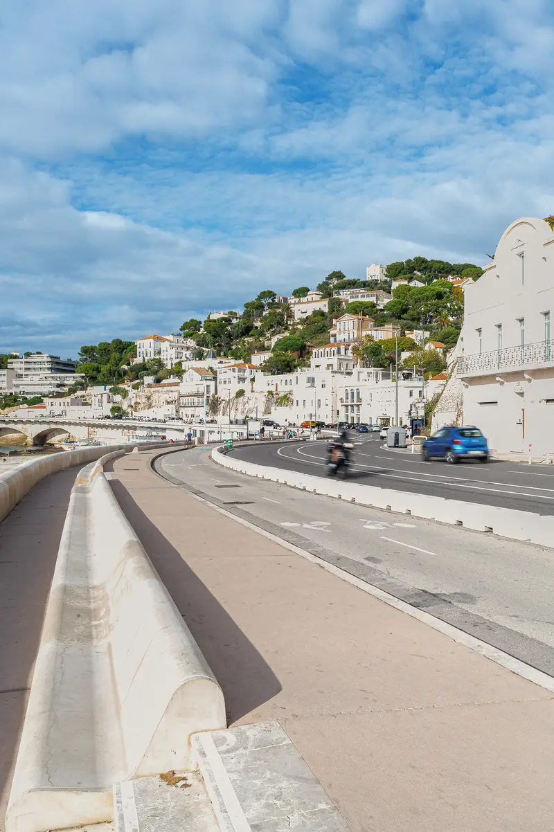 Coastal Road in Marseille, France with White Buildings and Hillside Backdrop