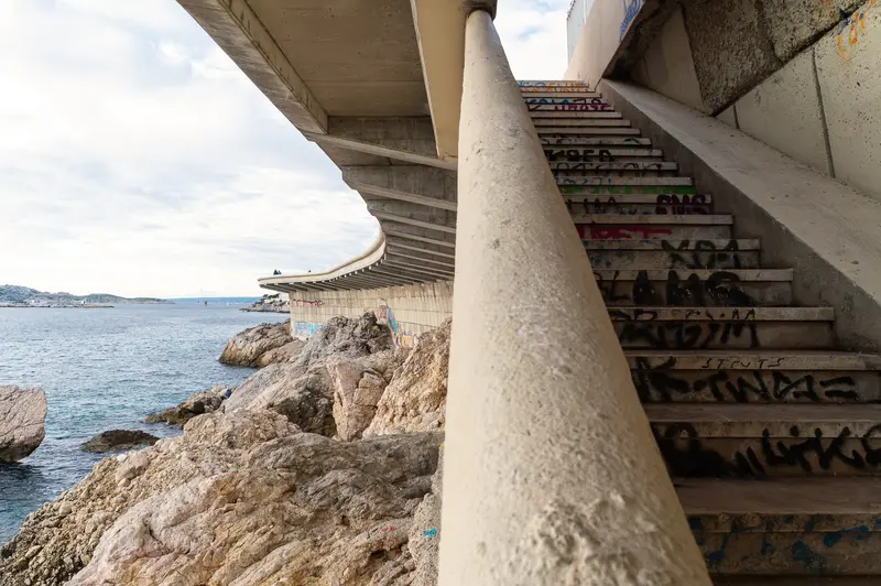 Concrete Staircase Overlooking Rocky Marseille Coastline with Graffiti Steps