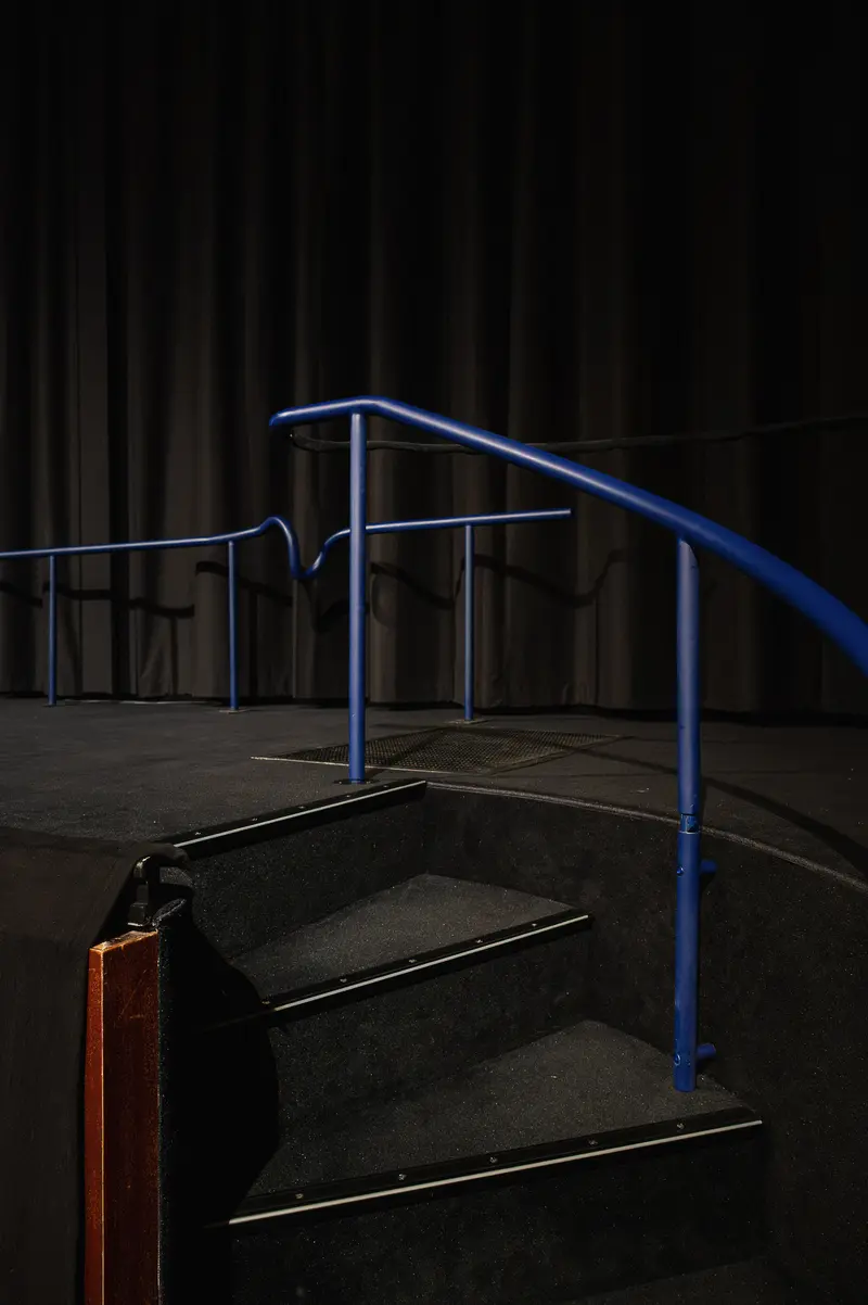 Blue Handrail and Dark Concrete Stairs in Minimalist Urban Setting