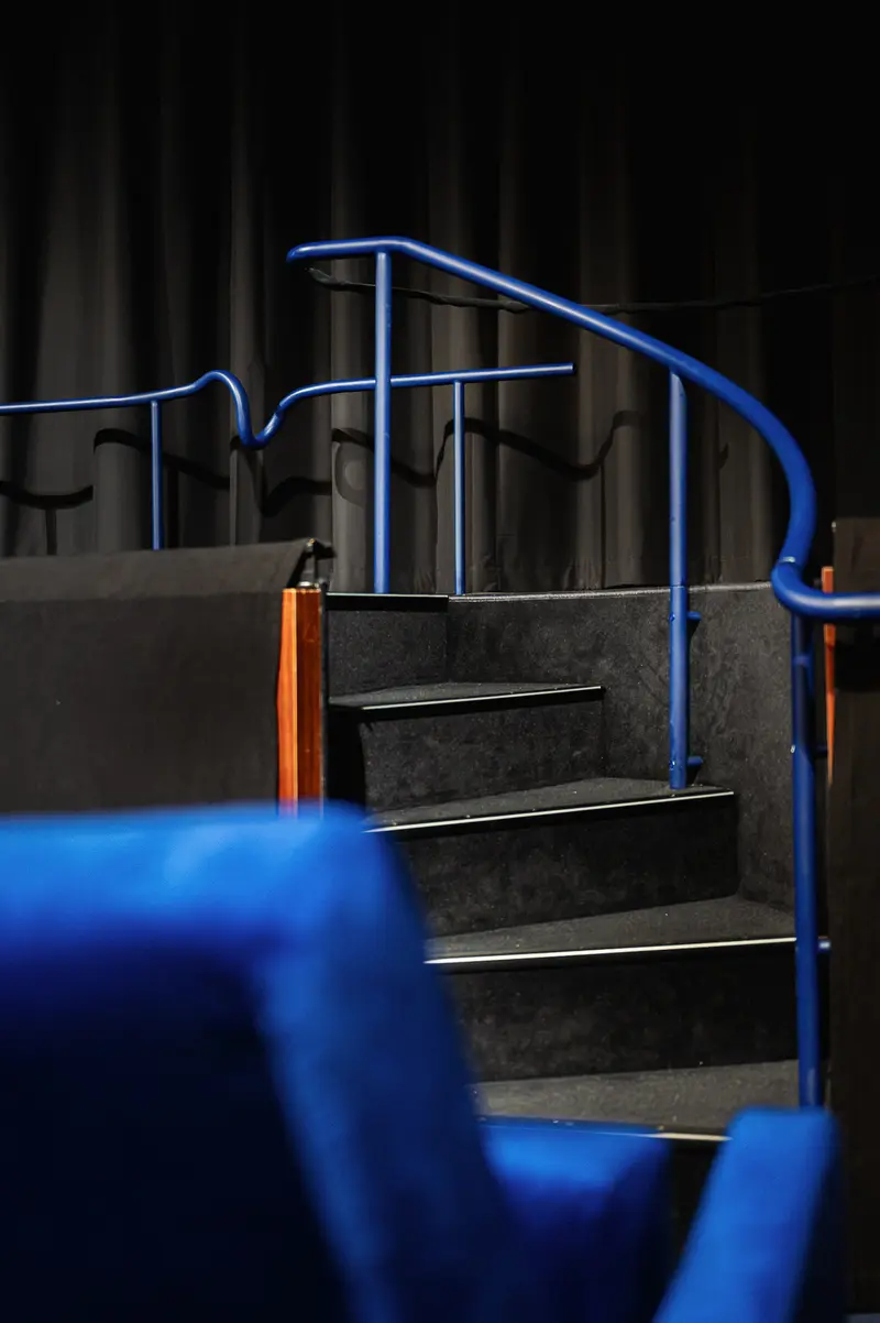 Blue-Lit Staircase with Metal Railing at Stadtkino Theater