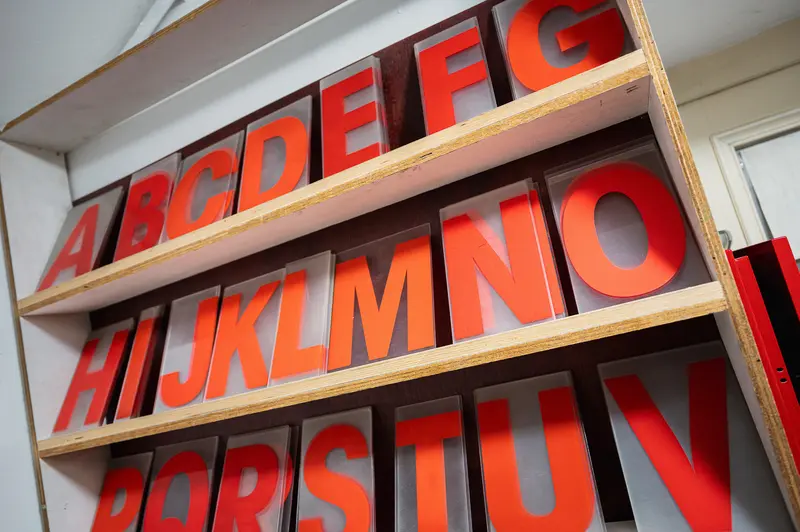 Alphabetical Typography Display with Red Letters on Wooden Shelves