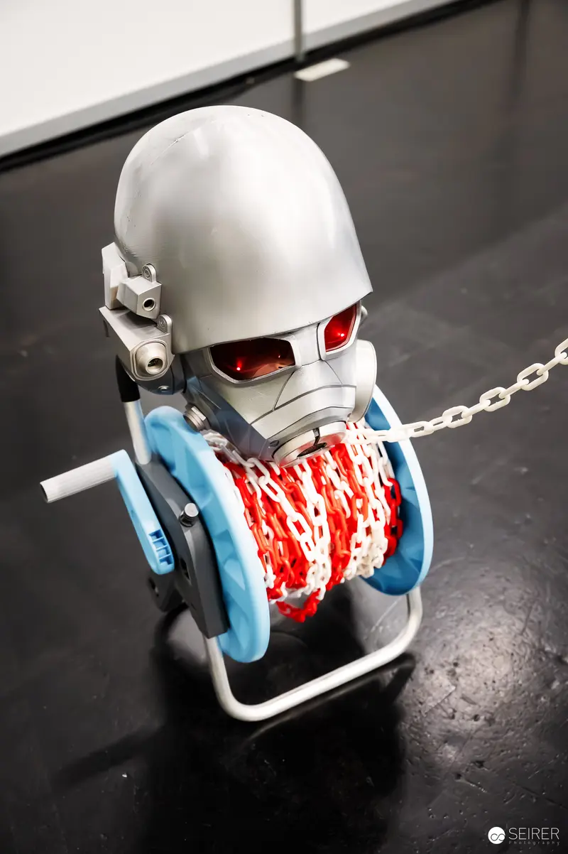 White Robotic Figure with Red Eyes and Chain Restraint