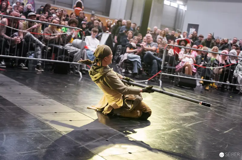 Yellow-Costumed Performer Demonstrates Combat at Vienna ComicCon 2025