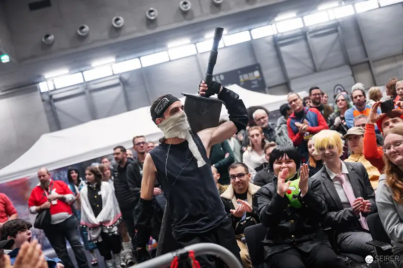 Costumed Performer Raises Prop at Vienna ComicCon 2025 Schaukampf Performance