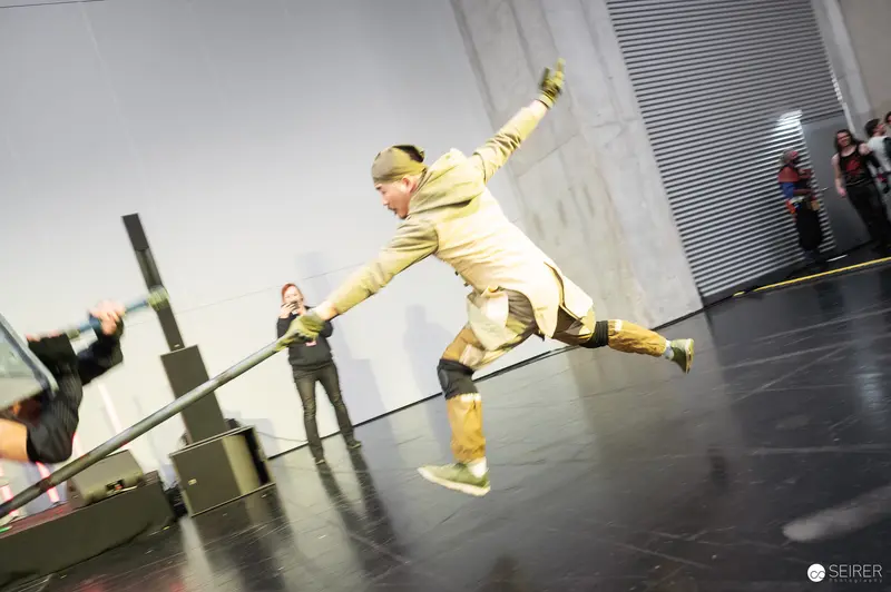 Yellow-Costumed Performer Leaps During "Bis einer weint" at Vienna ComicCon 2025