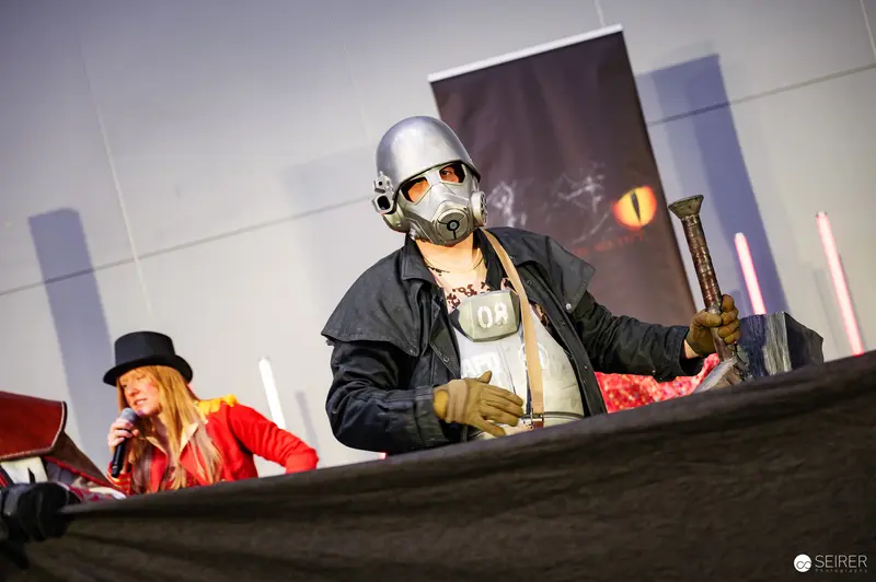 Performer in Gas Mask and Silver Helmet at Vienna ComicCon 2025 "Bis einer weint" Schaukampf