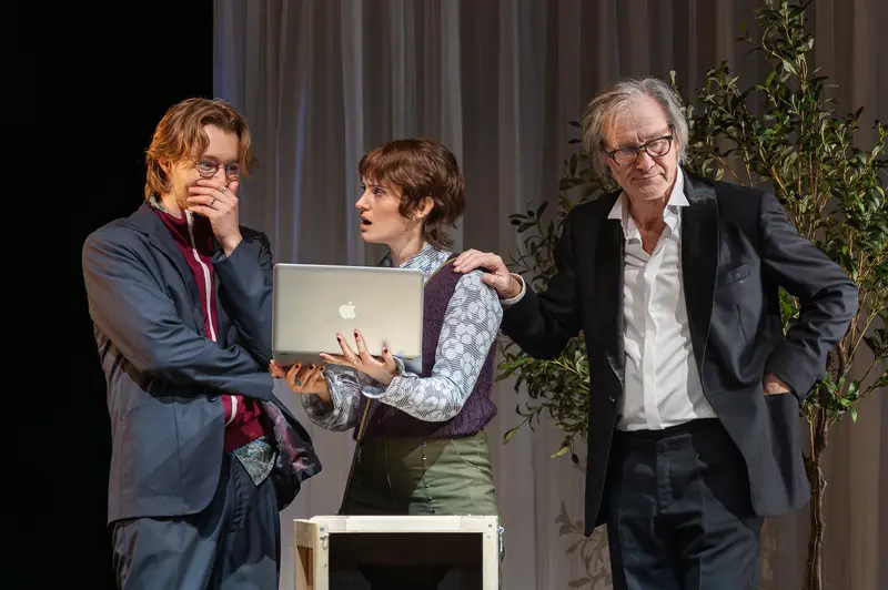 Three Performers Examine Laptop on Stage at Kammerspiele der Josefstadt