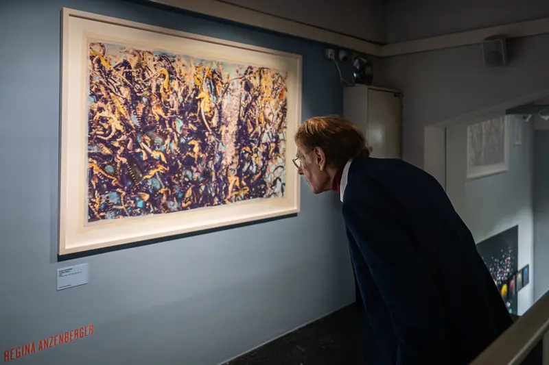 Visitor Examining Abstract Expressionist Artwork in Gallery Exhibition