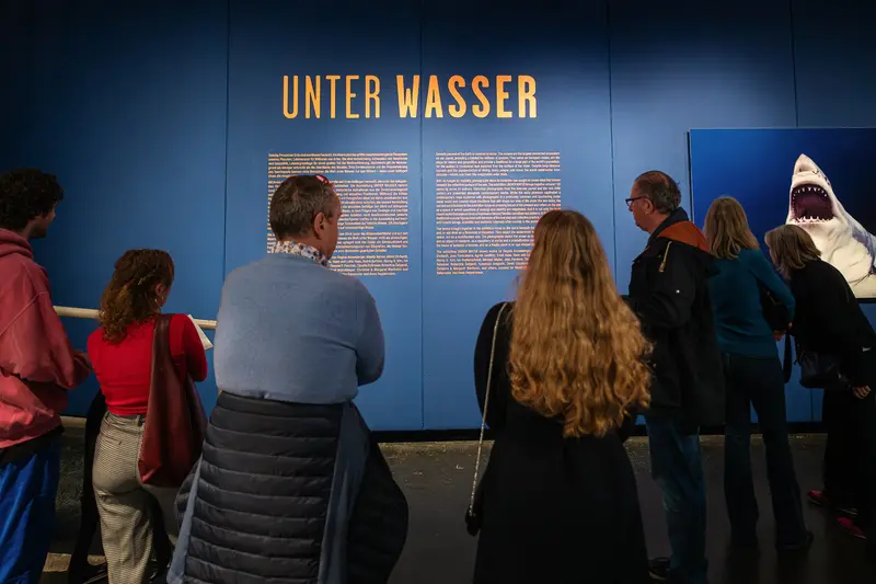Museum visitors reading "Unter Wasser" exhibition display panels