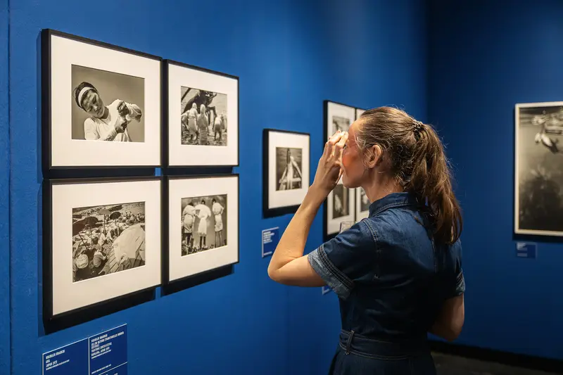 Visitor Examining Black-and-White Photographs in Museum Gallery